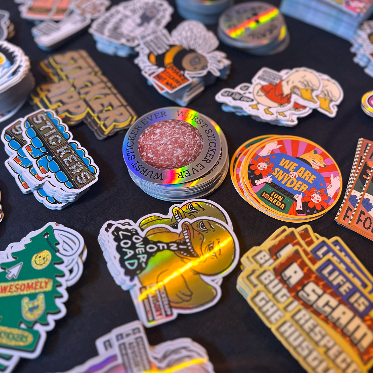 Die-Cut Stickers imprimés dans divers matériaux et tailles sur une table sombre