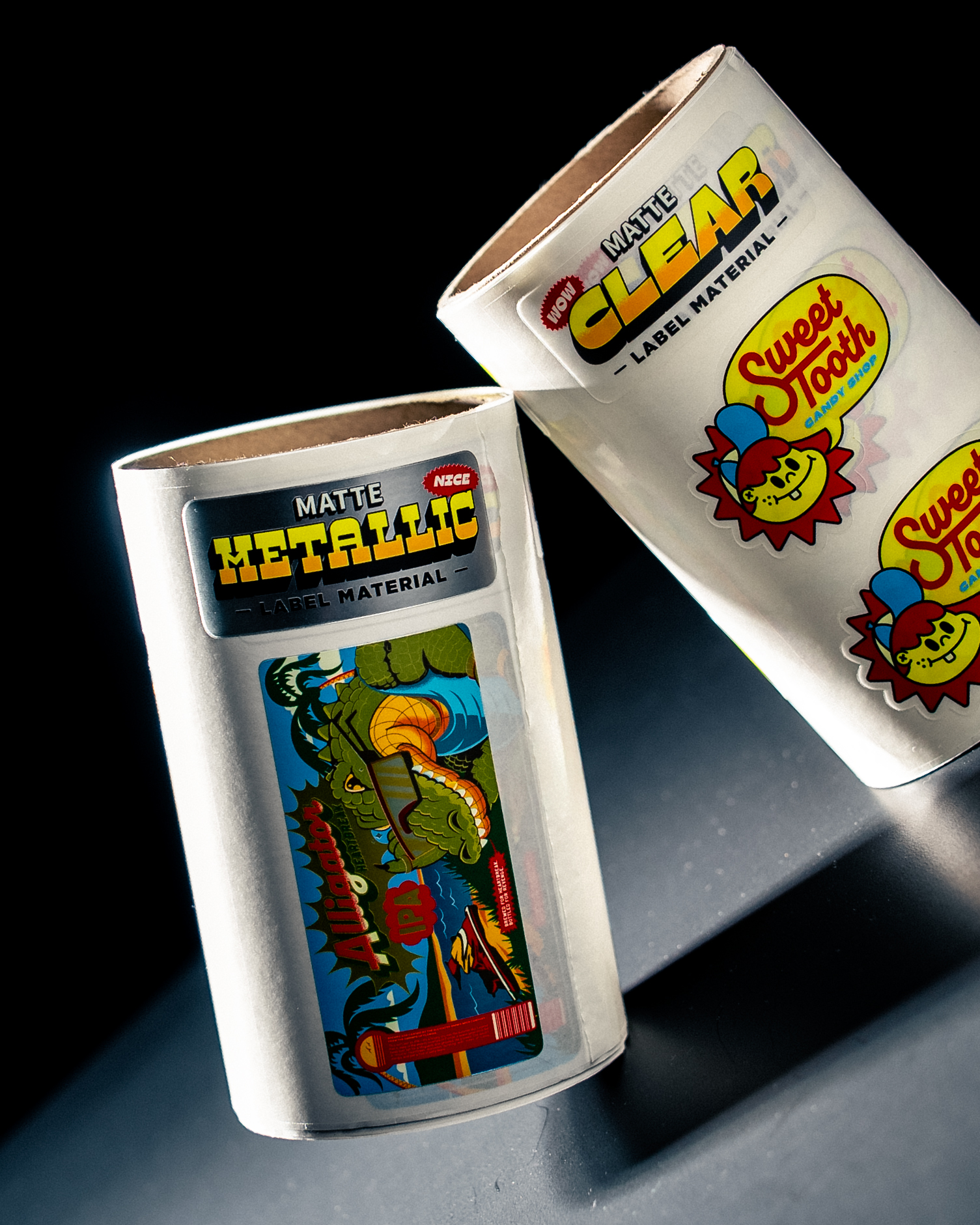 Deux rouleaux d'étiquettes échantillons marqués « Matte Metallic » et « Matte Clear », avec une étiquette Alligator IPA et des étiquettes Sweet Tooth Candy Shop