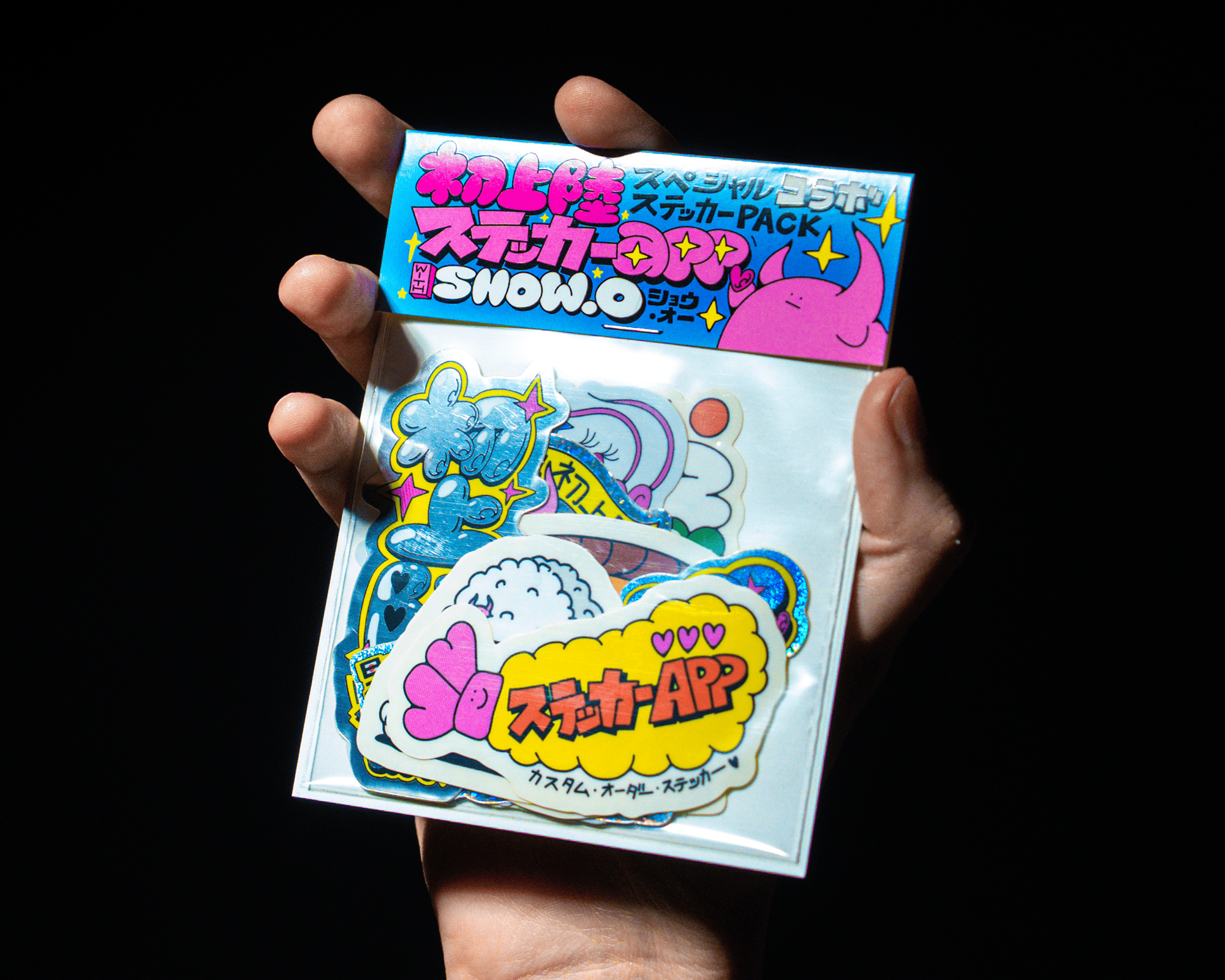 Une main tenant un pack de stickers