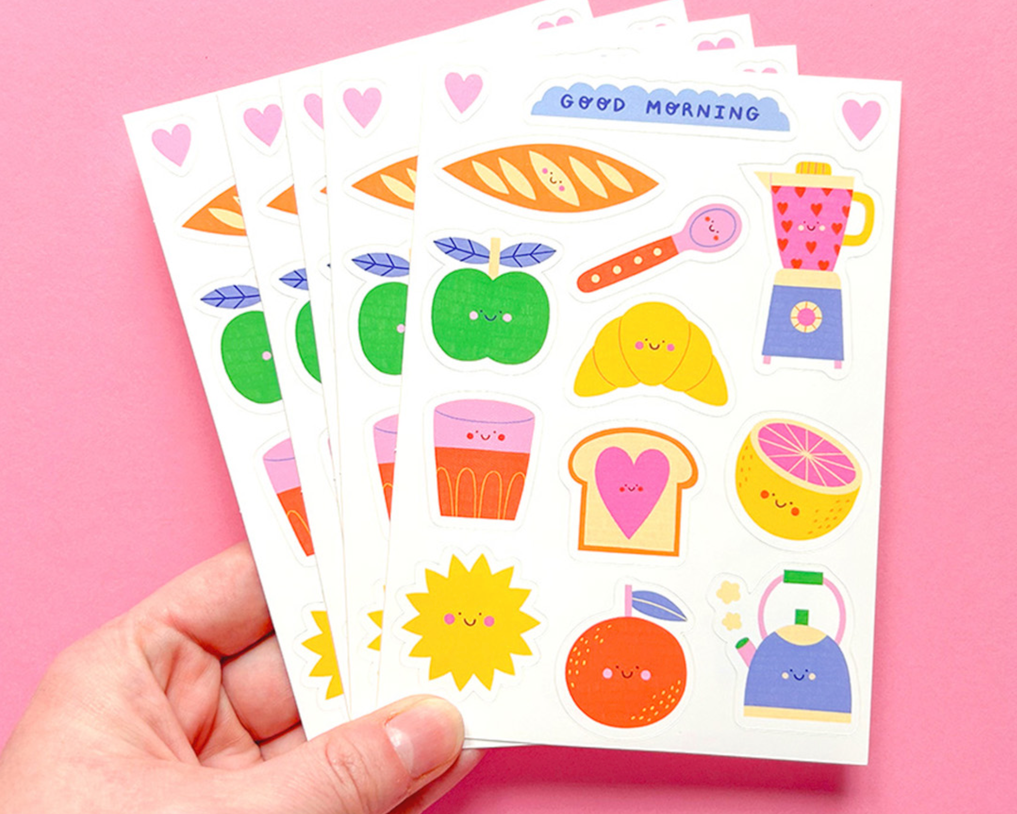 Five colorful sticker sheets on a pink background