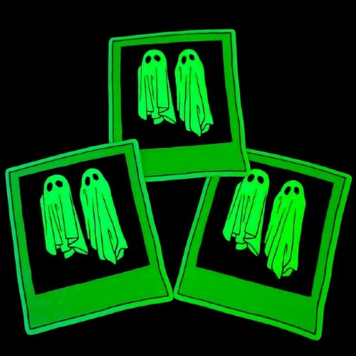 Three green ghost glow in the dark stickers on a black background